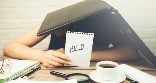Femme fatiguée qui tient un papier avec écrit "help" dans sa main