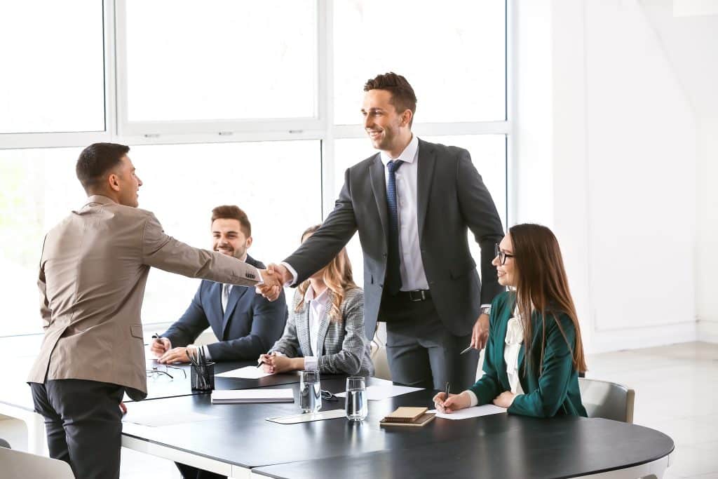 Professionnels en réunion. Deux hommes se serrent la main.