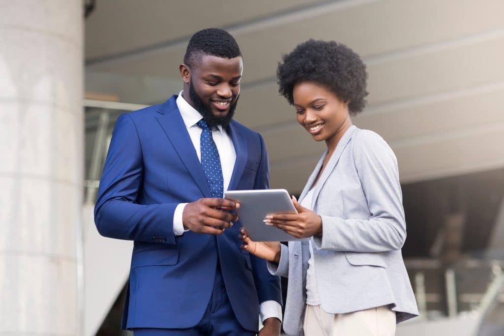 Professionnels utilisant une tablette et parlant de projets bancaires