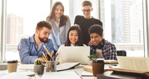 Etudiants regroupés autour d'un ordinateur travaillant sur un projet